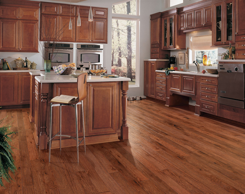 Wood cabinets with matching hardwood floor in kitchen. 